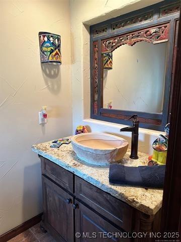 bathroom featuring tile patterned flooring, baseboards, and vanity