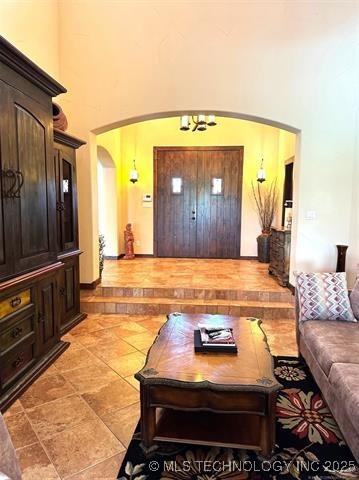 living room featuring a towering ceiling and arched walkways