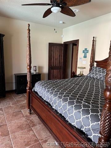 tiled bedroom with a ceiling fan