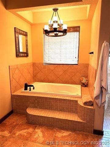 bathroom featuring a bath, tile patterned floors, and a chandelier