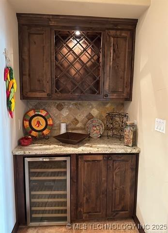 bar with a dry bar, decorative backsplash, and wine cooler