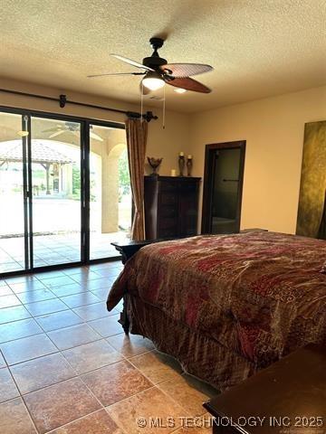 bedroom with light tile patterned flooring, ceiling fan, a textured ceiling, and access to outside