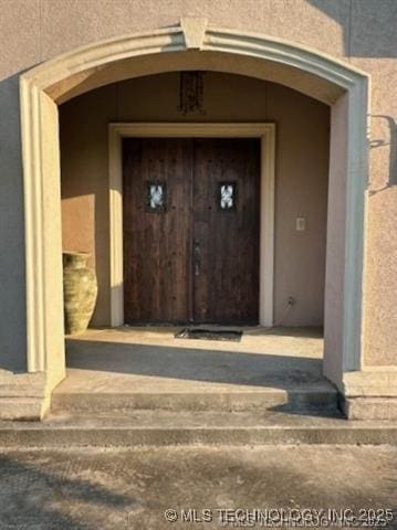 entrance to property featuring stucco siding
