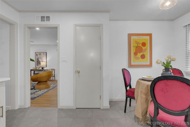 tiled dining space featuring baseboards, ornamental molding, and visible vents