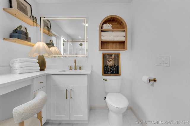 bathroom featuring marble finish floor, toilet, vanity, baseboards, and walk in shower