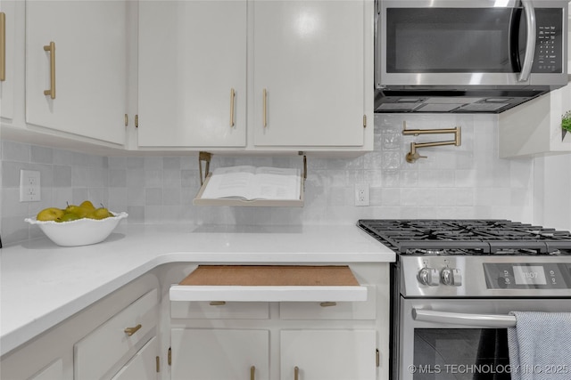 3644 S Louisville Ave, Tulsa, OK 74135 - kitchen with appliances with stainless steel finishes, white cabinets, light countertops, and backsplash