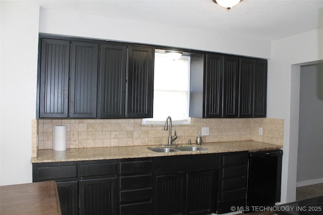 kitchen with black dishwasher, dark cabinets, decorative backsplash, and a sink