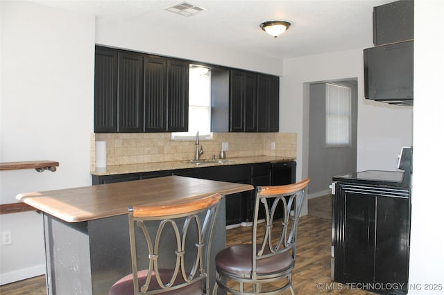 kitchen featuring dark wood-style floors, a sink, black electric range, backsplash, and visible vents
