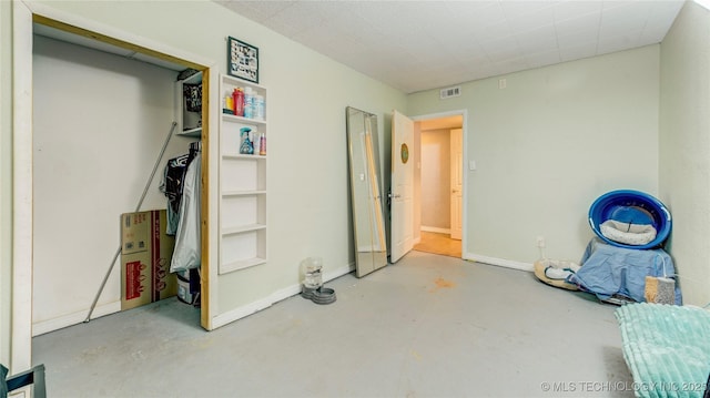 unfurnished bedroom featuring concrete floors, visible vents, and baseboards