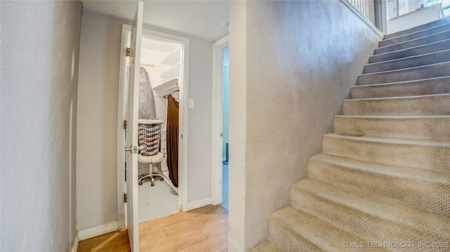 stairway with baseboards and wood finished floors
