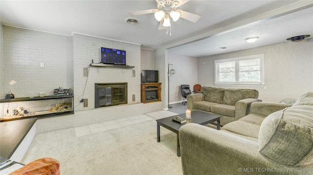 carpeted living room with a brick fireplace, visible vents, and ceiling fan