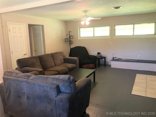living room featuring visible vents, finished concrete floors, and ceiling fan