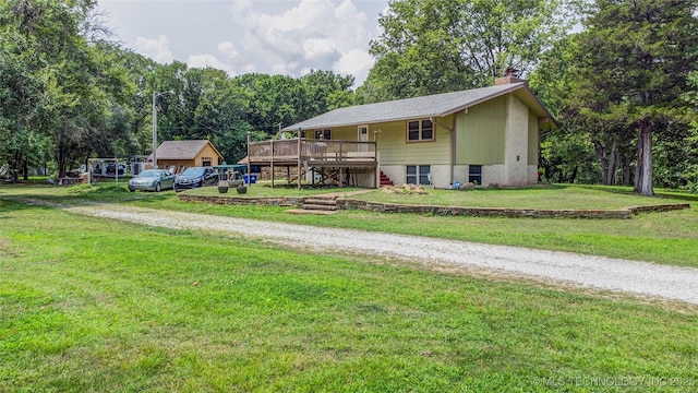 single story home featuring a front lawn, a chimney, stairs, and a deck