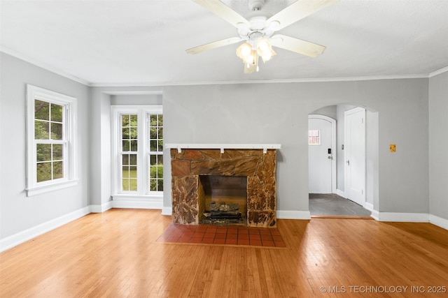 1201 E 18th, Ada, OK 74820 - unfurnished living room featuring crown molding, arched walkways, baseboards, and wood-type flooring