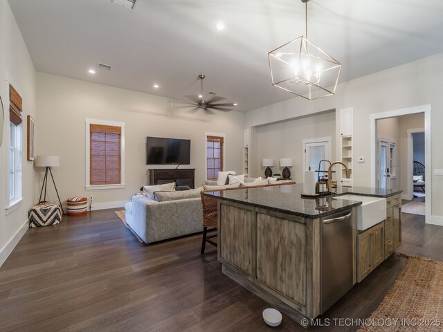 31 Park St, Carlton Landing, OK 74432 - kitchen featuring stainless steel dishwasher, a sink, dark stone countertops, dark wood-style flooring, and an island with sink