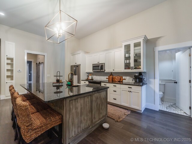 31 Park St, Carlton Landing, OK 74432 - kitchen featuring white cabinets, dark wood finished floors, stainless steel appliances, decorative backsplash, and glass insert cabinets