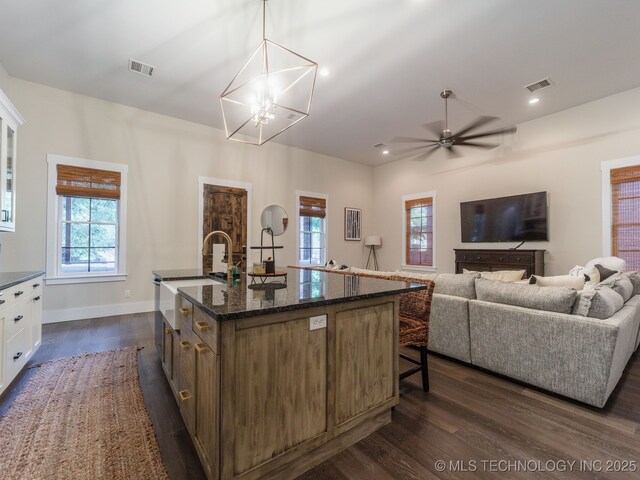 31 Park St, Carlton Landing, OK 74432 - kitchen with a kitchen breakfast bar, dark stone counters, dark wood-style flooring, visible vents, and white cabinetry