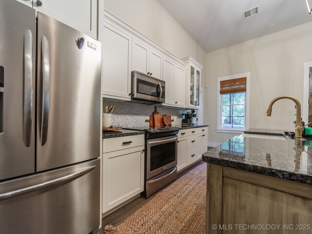 31 Park St, Carlton Landing, OK 74432 - kitchen with backsplash, visible vents, a sink, appliances with stainless steel finishes, and white cabinetry