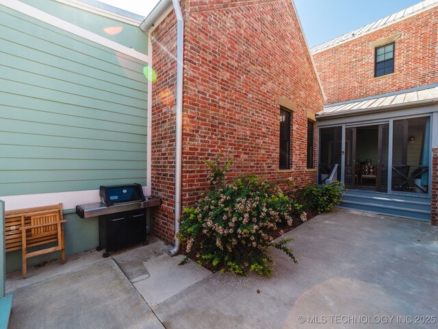 31 Park St, Carlton Landing, OK 74432 - exterior space with brick siding, a standing seam roof, a patio area, and metal roof