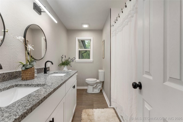 8219 S 67th W Ave, Tulsa, OK 74066 - bathroom with double vanity, a sink, wood finished floors, and toilet