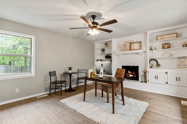 8219 S 67th W Ave, Tulsa, OK 74066 - office space featuring visible vents, a brick fireplace, wood finished floors, and built in shelves