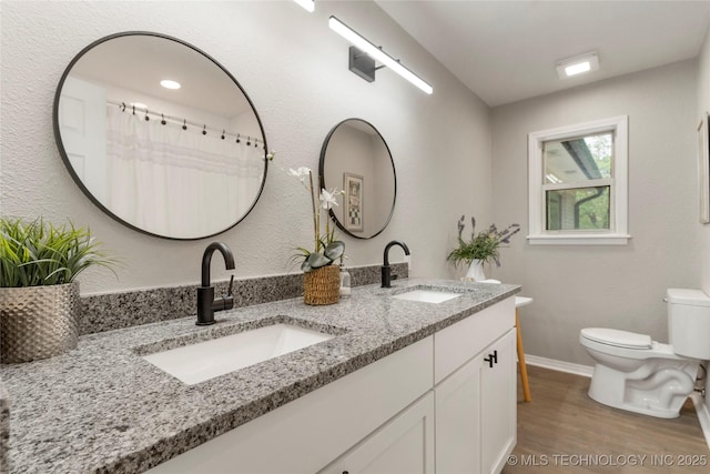 8219 S 67th W Ave, Tulsa, OK 74066 - bathroom featuring double vanity, toilet, a sink, and wood finished floors
