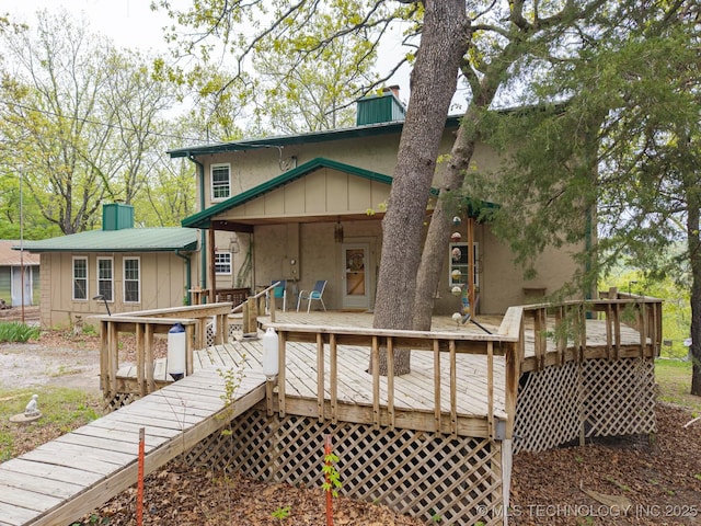 view of front of property with stucco siding, a chimney, and a deck