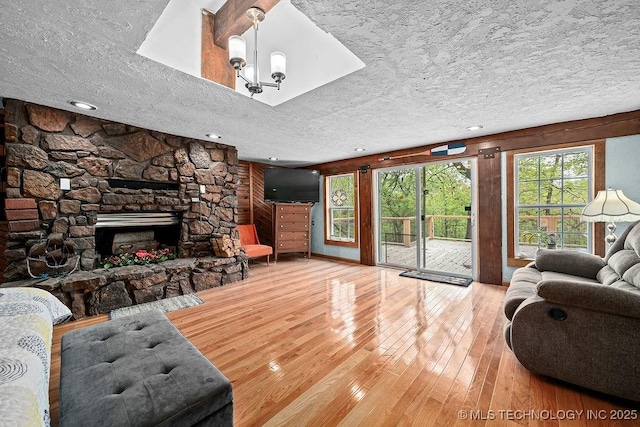 living area with hardwood / wood-style flooring, a textured ceiling, and a fireplace