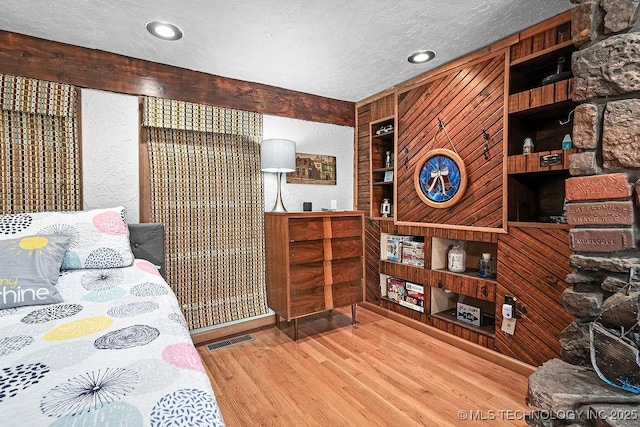 bedroom featuring a textured ceiling, wood finished floors, and visible vents