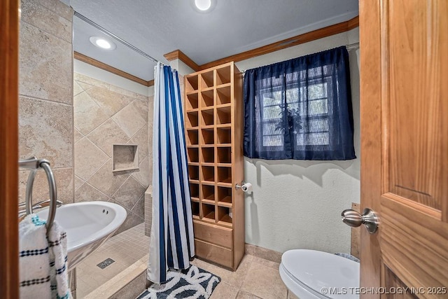 full bathroom featuring toilet, tile patterned floors, a shower with curtain, baseboards, and ornamental molding