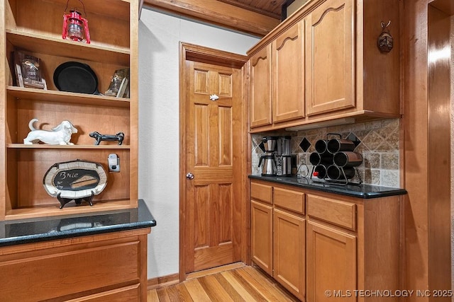 bar featuring light wood-style floors and decorative backsplash