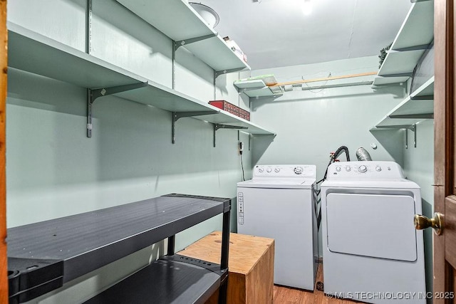 laundry area featuring washing machine and dryer, light wood-style flooring, and laundry area
