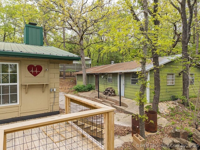 exterior space with a chimney and metal roof