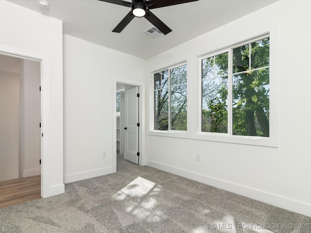 unfurnished bedroom with ceiling fan, baseboards, carpet flooring, and visible vents