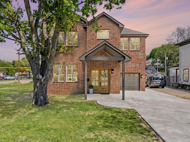 traditional home with concrete driveway, an attached garage, brick siding, and a lawn