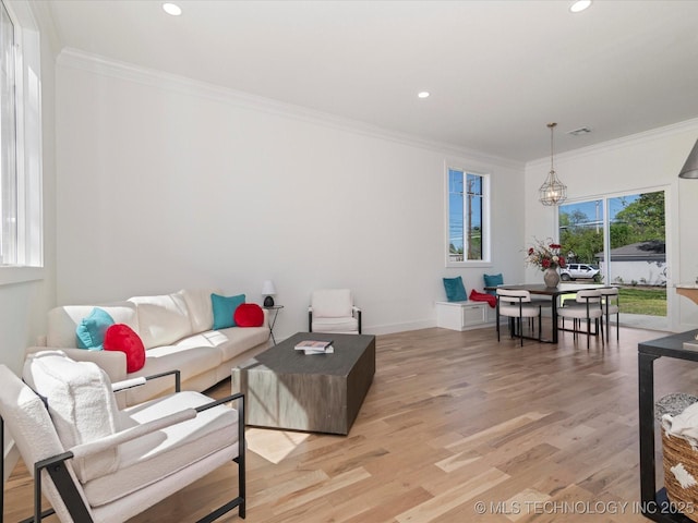 living area with recessed lighting, visible vents, ornamental molding, light wood-type flooring, and baseboards