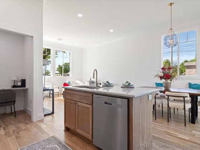 kitchen featuring light countertops, dishwasher, ornamental molding, a sink, and light wood-style flooring