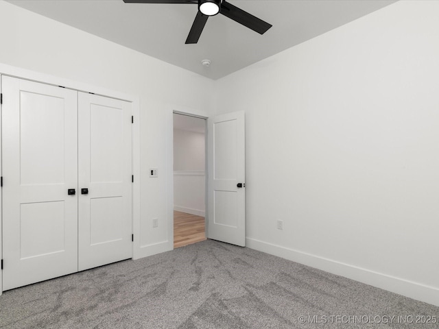 unfurnished bedroom with baseboards, a ceiling fan, carpet flooring, and a closet
