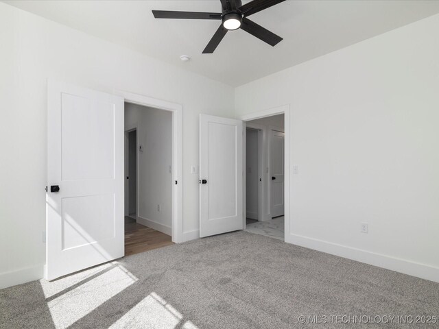 unfurnished bedroom with baseboards, a ceiling fan, and carpet flooring
