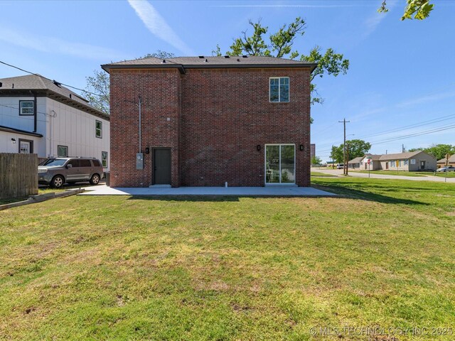 back of property featuring brick siding, a yard, and a patio