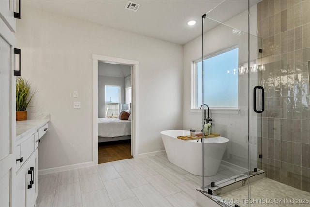 bathroom featuring a freestanding tub, a shower stall, visible vents, and baseboards