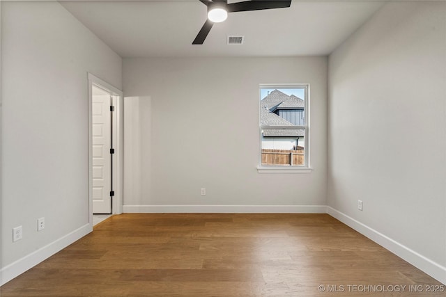 spare room with visible vents, baseboards, wood finished floors, and ceiling fan
