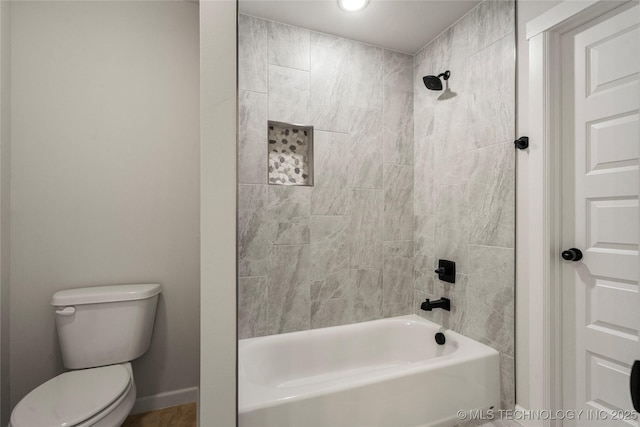 bathroom with toilet, shower / bathtub combination, and baseboards