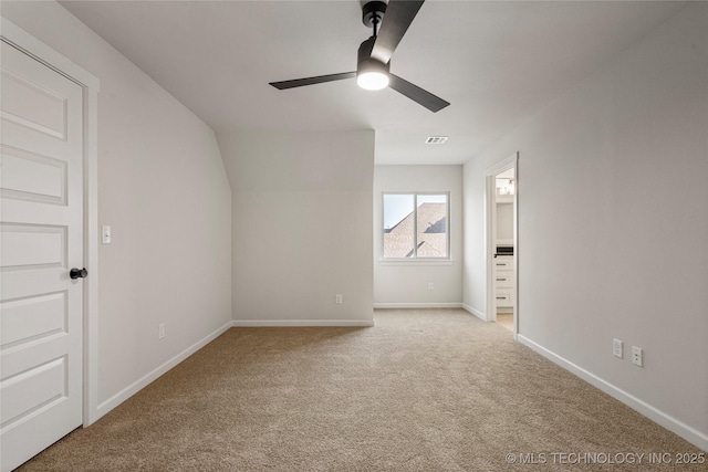 unfurnished bedroom featuring ensuite bath, light carpet, baseboards, and visible vents