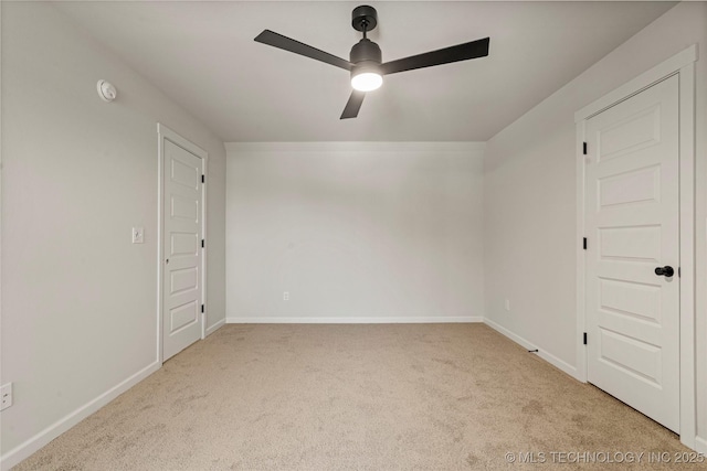 empty room featuring carpet flooring, baseboards, and ceiling fan