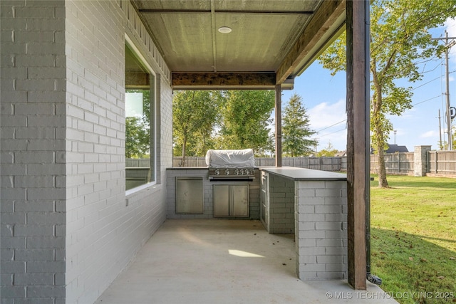 view of patio with grilling area, an outdoor kitchen, and a fenced backyard