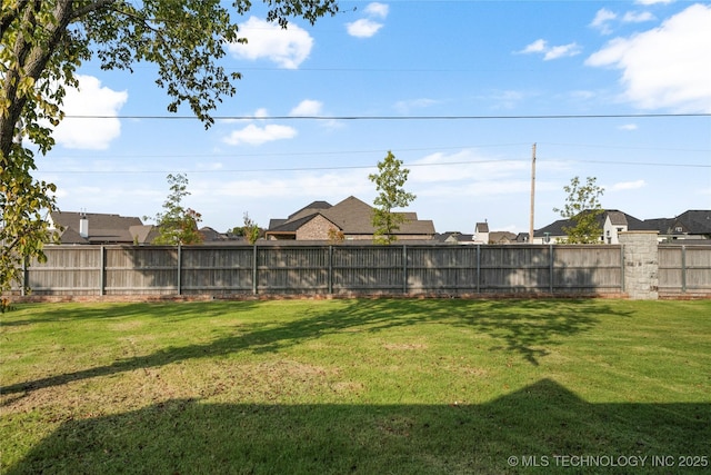 view of yard featuring a fenced backyard and a residential view