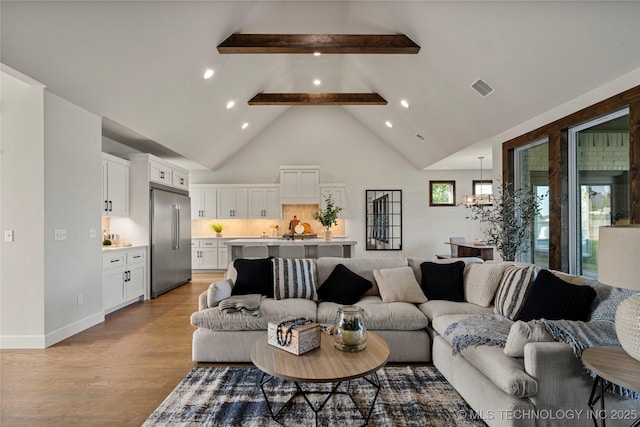 living area featuring light wood finished floors, beam ceiling, visible vents, recessed lighting, and high vaulted ceiling