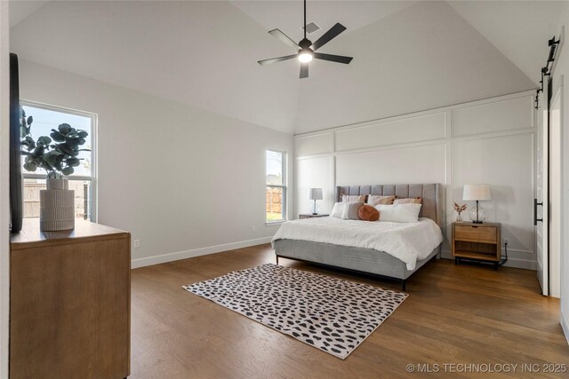 13676 S 23rd St, Bixby, OK 74008 - bedroom featuring a barn door, multiple windows, dark wood-style floors, high vaulted ceiling, and a ceiling fan