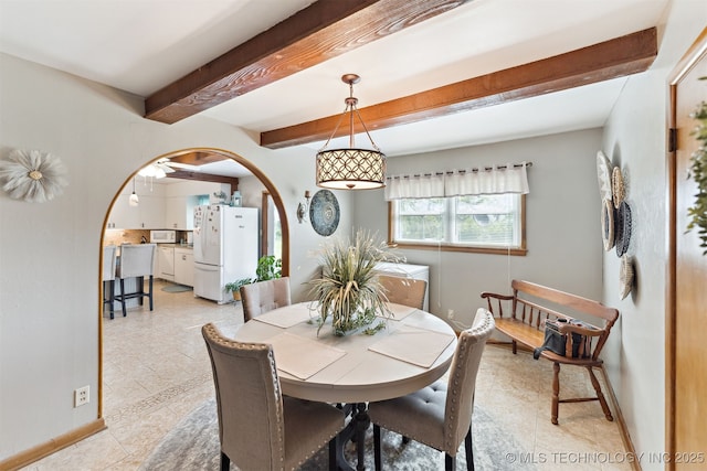 904 N Morningside Dr, Vinita, OK 74301 - dining room featuring beam ceiling, baseboards, arched walkways, and light tile patterned floors